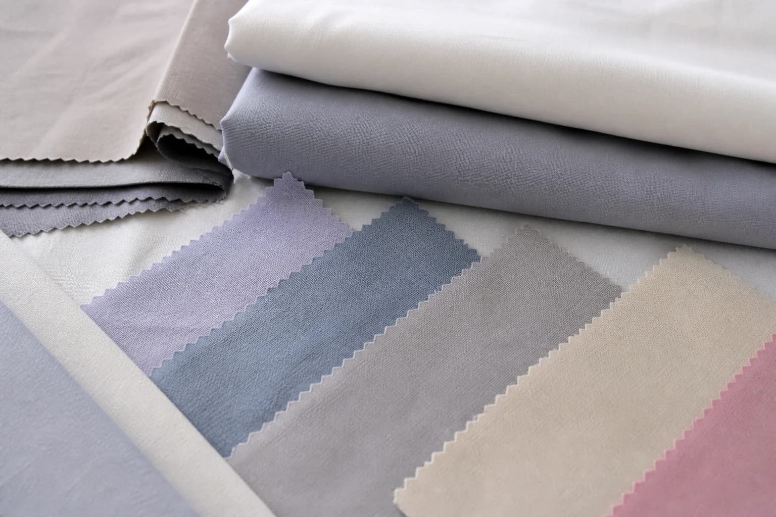 Échantillons de tissu teint et draps pliés pour comparer couleur et dimensions.