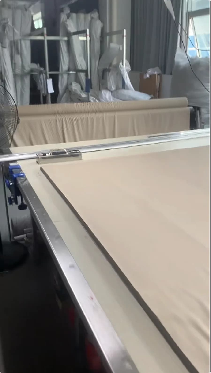 Greige cotton laid out on the spreading and inspection table before cutting