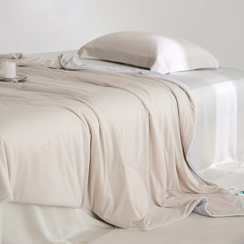 Folded smooth lustrous quilt showing the sheen and drape buyers associate with premium silk bedding